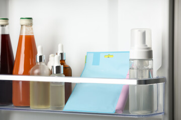 Different cosmetic products on shelf in refrigerator