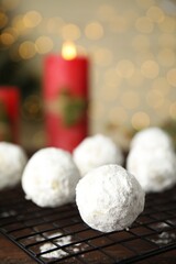 Tasty snowball cookies on cooling rack, closeup. Christmas treat