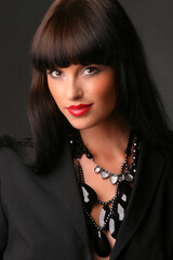 Portrait of a beautiful fashion girl brunette in the studio in blackleather  suit retro 90s vintage...