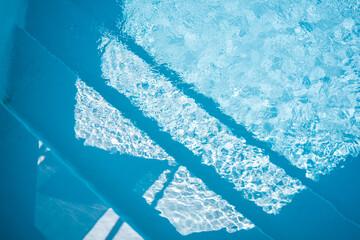 Steps in the pool photographed from above. View of clear cool water. Joining a pool party, swimming...