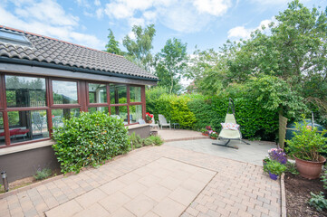 Patio and sunroom to the rear of a modern bungalow house.