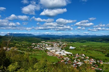 Fototapeta na wymiar View of the town of Pivka surrounded by fields and forest with Nanos mountain and other hills in Notranjska, Slovenia