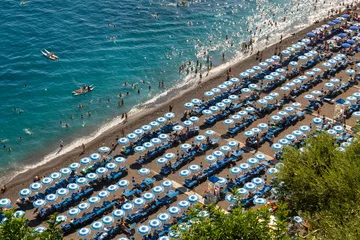 Photo sur Plexiglas Plage de Positano, côte amalfitaine, Italie Plage de Positano sur la célèbre côte amalfitaine en Italie. Des rangées de parasols ou de parasols et des centaines de touristes se prélassent au soleil ou se baignent dans la mer turquoise. Destination de vacances populaire près de Naples