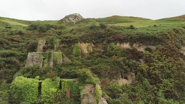 Porth Wen aerial reversing view abandoned Victorian industrial chimney brickwork factory remains on Anglesey eroded coastline