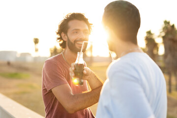 Gay couple embracing and showing their love. Young men drinking juice..