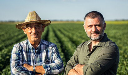 Portrait of two farmers in a soy field.