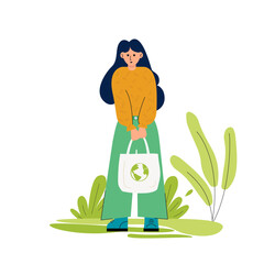 There is a woman with eco-friendly bag in her hands. She is going to buy groceries. She cares about the environment. Her bag with the green planet. There is an abstract background.