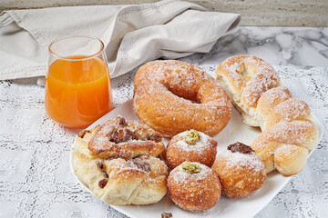 Brioche of various shapes and sizes, with sugar and orange juice