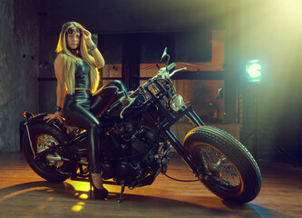Naklejka na ściany i meble Young woman sitting on motorcycle