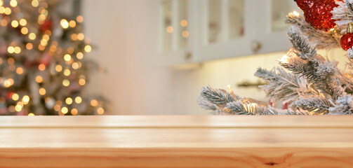 Empty wooden table on the background of christmas tree and blurred christmas kitchen, golden bokeh.Christmas background. Merry Christmas and Happy New Year! Ready for product montage.Mockup.