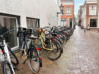 Fototapeta na wymiar Many parked bicycles near building on city street