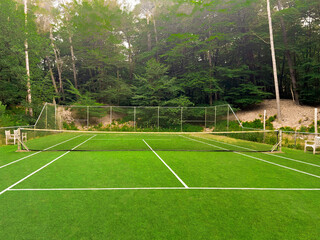 Tennis court with green grass and net outdoors