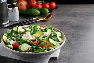Plate of delicious cucumber salad served on grey table. Space for text