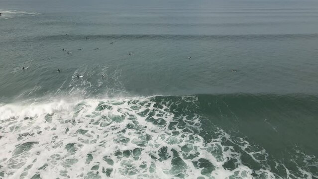 Surfers surf on waves with surfboards at the Pointe de la Torche in Brittany