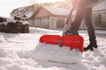 Person shoveling snow outdoors on winter day, closeup