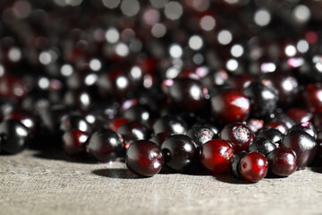 Many black elderberries (Sambucus) on grey table, closeup