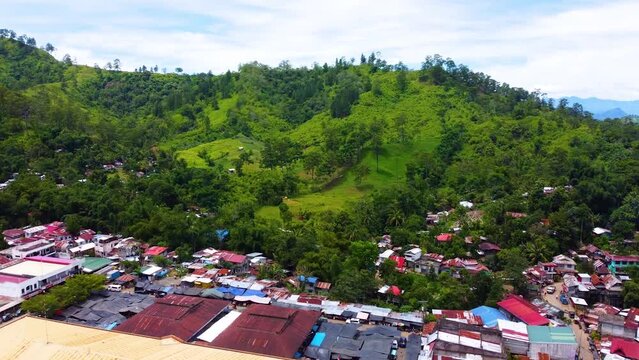 Tilt down drone shot of a mountain down to market place