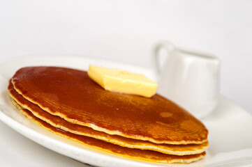 Pancakes served with butter and maple syrup