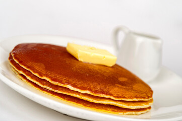 Pancakes served with butter and maple syrup