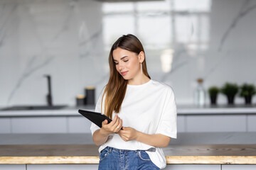 Young woman using a digital tablet in the kitchen