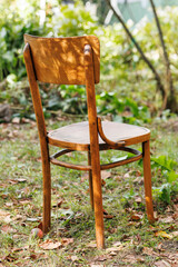 a wooden carved chair stands in the garden
