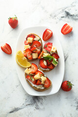 Strawberry toasts with almon and cheese