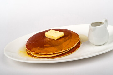 Pancakes served with butter and maple syrup