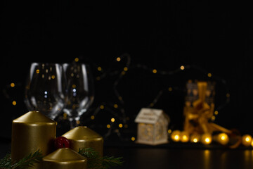 Three extinguished Christmas golden candles, decorated with sprigs of spruce and red berries, stand...