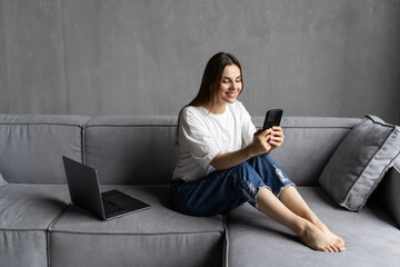 Calm attractive woman sit on sofa using smartphone. Generation and modern tech everyday usage for fun, making distant order, communication remotely, web surfing, internet connection concept