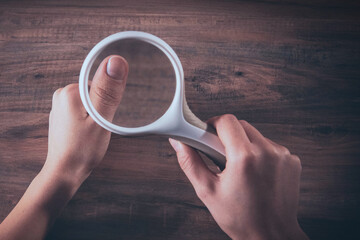 girl checks nails with a magnifying glass
