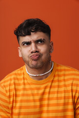 Fototapeta premium Young handsome stylish frowning man with puckered lips and piercing