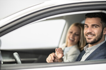 Shot of a cheerful beautiful couple sitting in a car together.
Man kisses her hand