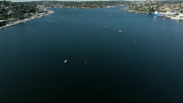 Aerial shot tilting up from Lake Union to reveal numerous boats out playing on the water.