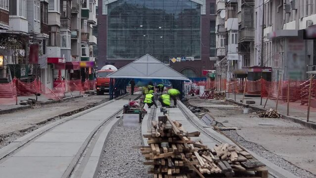Tram rails after their installation and integration into concrete plates on the road timelapse. The process of reconstruction of tram tracks on a background