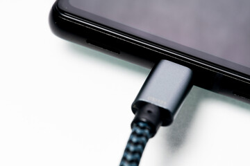 充電中のスマートフォン 白背景 クローズアップイメージ