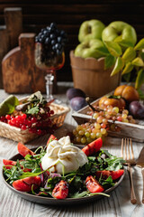 Burrata with arugula and tomatoes. Autumn still life.