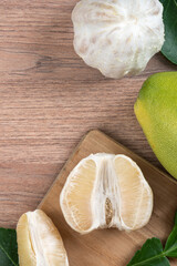 Fresh pomelo fruit on bright wooden table background.