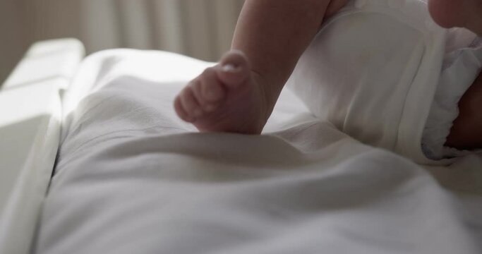 New born baby boy lies on the back on bedsheet