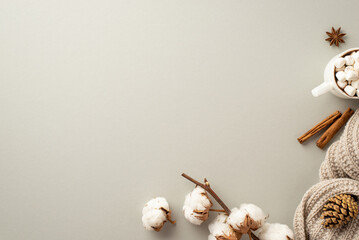 Winter concept. Top view photo of cup of cocoa with marshmallow knitted plaid cinnamon sticks anise pine cone and cotton branch on isolated light grey background with copyspace