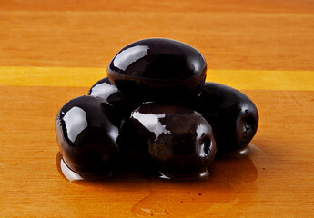 Azeitonas pretas com azeite em fundo de madeira