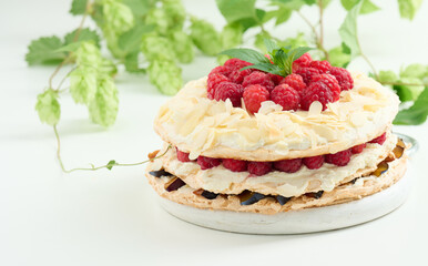 Round meringue pie with fresh raspberries on a white background, Pavlova dessert