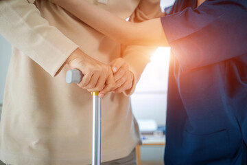 Nurse helps senior man practice walking at nursing home,Caregiver serve physical therapy for older patient to exercise and practice walking on walker or cane.