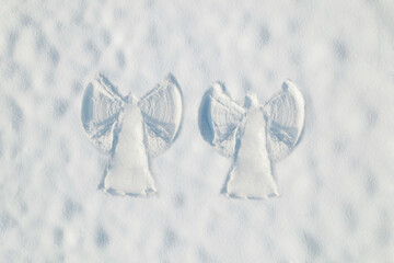 Snow two angel couple print on a snow covered land. Aerial, top view. Drone photo. Winter