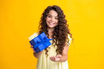 Happy teenager portrait. Child with gift present box on isolated background. Presents for birthday,...