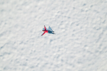 Happy woman lying on the snow at winter, christmas day. Drone, top, aerial view.