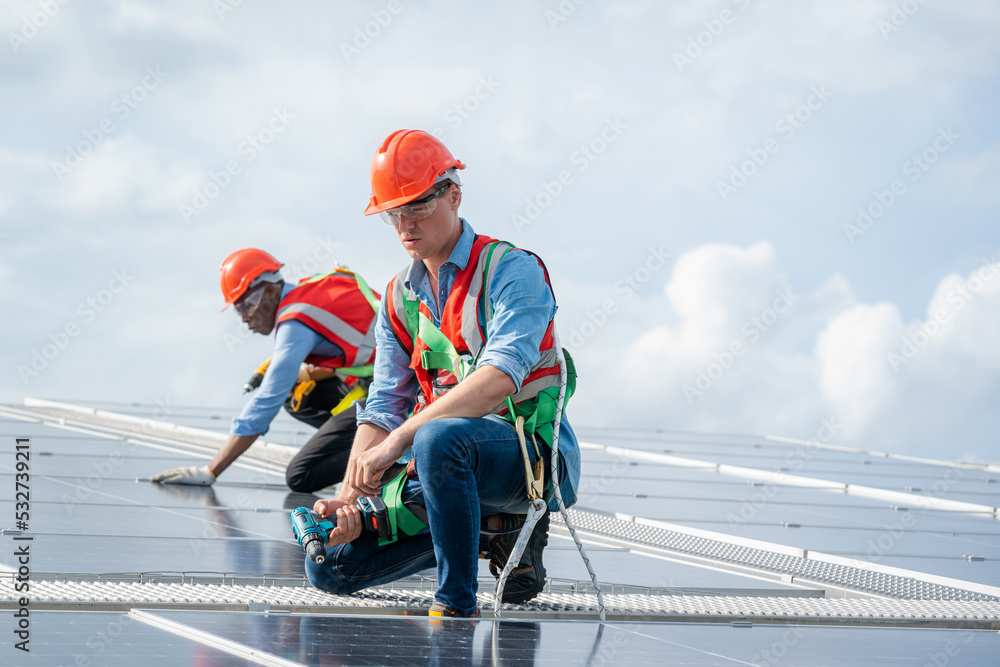 Poster engineers checking the operation of the system solar cell on roof at factory,alternative energy to c