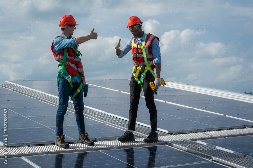 Aufkleber technician wearing safety harness belt during installing the solar panels on roof structure of build