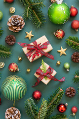 Wrapped gift boxes between Christmas decorations and green fir branches on green