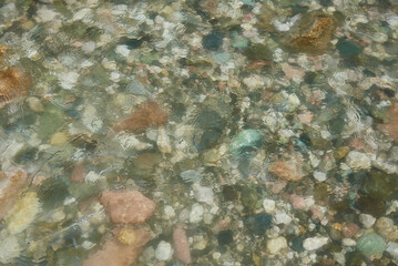 abstract blurred background. A fragment of a mountain river. Colorful stones under the water.