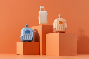 Concept travel or moving with animal, flight, safety. Plastic cage, pet carrier and suitcase on orange background